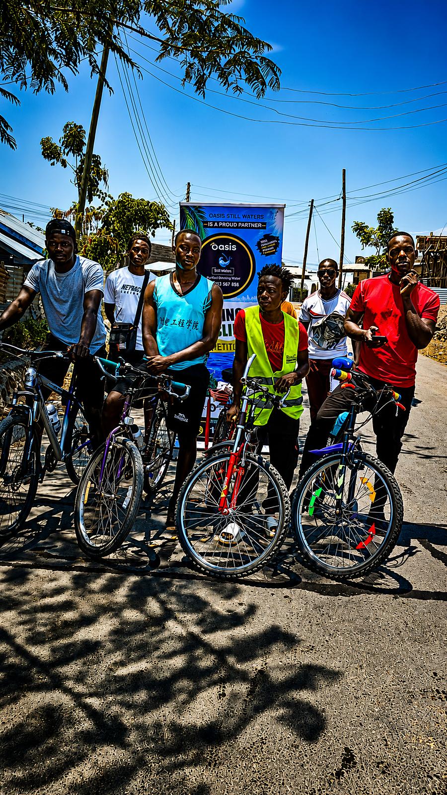 A larger group of cyclists gathered with their bikes ahead of the Rusinga Cycling Competition